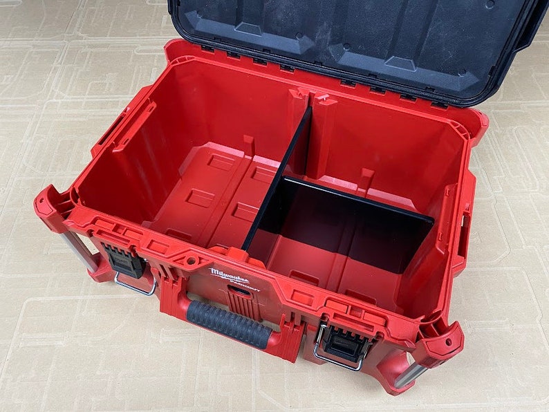 May include: Red and black tool box with a removable divider inside. The box has a handle and a latch.