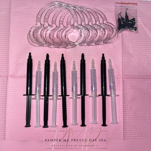 May include: A set of eight clear plastic mouth trays and eight syringes filled with a white gel. The syringes are labeled "PAMPER ME PRETTY DAY SPA BECAUSE YOU'RE SO WORTH IT".