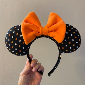 May include: Black headband with orange and white polka dot fabric mouse ears and a large orange bow.