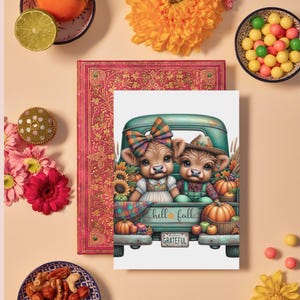 May include: A greeting card featuring two cartoon cows in a teal pickup truck filled with pumpkins and sunflowers. The card has the words "hell fall" and "grateful" on it. The card is surrounded by flowers, a decorative book, and bowls of candy and nuts.