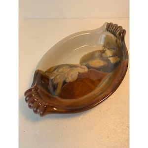 Puede incluir: Un plato para hornear de cerámica marrón y blanco con dos asas. El plato tiene un acabado esmaltado y un patrón de espiral único.