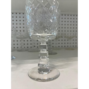 Puede incluir: Un juego de copas de vino de vidrio transparente con un patrón geométrico y un tallo cuadrado apilado.