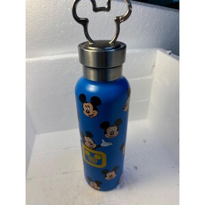 May include: A blue stainless steel water bottle with a Mickey Mouse design. The bottle has a silver lid with a Mickey Mouse shaped handle.