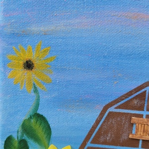 K&ouml;nnte beinhalten: Ein Gem&auml;lde, das eine braune Scheune vor einem blauen Himmel mit zwei gelben Sonnenblumen zeigt. Die Scheune hat eine Holzt&uuml;r und ein Fenster.