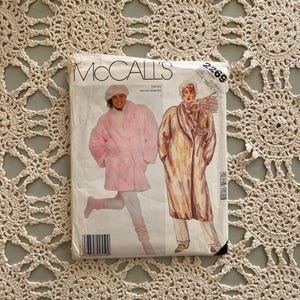 May include: McCall's sewing pattern for a coat, pattern number 2269. The pattern shows two different styles of coats, one in pink and one in brown. The pattern is for sizes 6-14.