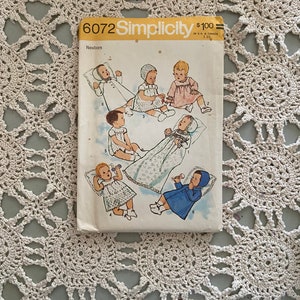 May include: Simplicity sewing pattern number 6072 for newborn baby clothes. The pattern includes six different outfits, including a dress, a gown, a coat, and a bonnet. The pattern is priced at $1.00.