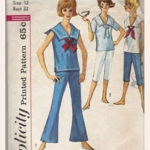 May include: A white ceramic mug with a black handle and the text "But First, Coffee" in a black, handwritten-style font. The mug is on a white surface.