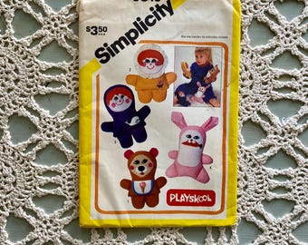 Puede incluir: Patrón de costura Simplicity vintage con diseños de juguetes de peluche. El paquete del patrón tiene un borde amarillo e incluye ilustraciones de un oso, un conejo y otros animales de peluche. El logotipo de Playskool es visible.