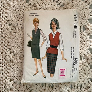 Puede incluir: Patrón de costura vintage McCall's para una falda, una blusa y un chaleco. El patrón es para señoritas y jóvenes, talla 12, busto 81 cm. El patrón presenta una falda de cuadros rojos y negros, una blusa blanca y un chaleco rojo.