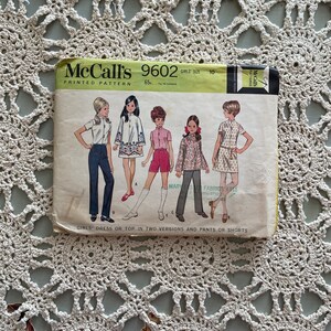 May include: McCall's 9602 Girls' Size 10 Printed Pattern for a dress or top in two versions and trousers or shorts. The pattern includes a black and white floral print, a solid red top, a solid blue top, and a solid white top.