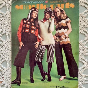 May include: Vintage "Smartie Pants" pattern cover featuring three women modeling crocheted outfits. The cover has a green background with the text "Columbia-Minerva" and "Exclusive Grota Plotty Designs."