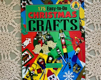 May include: A colorful book titled "175 Easy-to-Do Christmas Crafts" with various craft examples. The cover features a green banner with red text and illustrations of Christmas-themed crafts. The book is edited by Sharon Dunn Umnik.