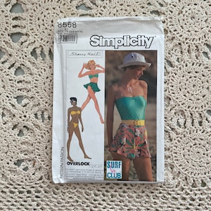 May include: Simplicity sewing pattern number 8558 for sizes 10, 12, and 14. The pattern includes instructions for making a swimsuit top and a skirt. The pattern is titled "Sherry Halt" and includes instructions for using an overlock or serger.