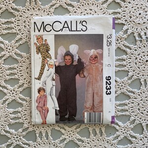 Pode incluir: Um padrão de costura McCall's vintage para fantasias infantis. O padrão apresenta ilustrações de crianças em fantasias de animais, incluindo um tigre, um rato e um coelho. O número do padrão é 9233.