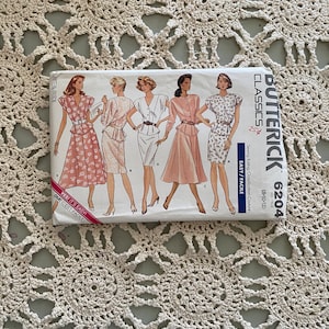 以下が含まれることがあります： さまざまなスタイルのドレス用のヴィンテージの裁縫パターン。パターンはバタークリームクラシックからで、番号は6204です。パターンはサイズ8、10、12用です。パターンは「簡単/ファシル」とラベル付けされています。