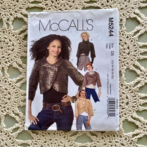 May include: McCall's sewing pattern M5244 featuring a woman wearing a leopard print jacket. The pattern includes multiple jacket styles and sizes D5 (12-14-16-18-20). The pattern is on a cream-colored background.