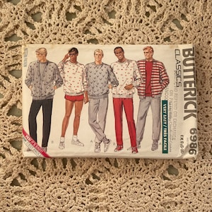 Puede incluir: Un patrón de costura para un suéter de hombre. El patrón incluye cinco estilos de suéter diferentes, incluyendo un suéter a rayas, un suéter con cuello en V y un suéter con un patrón geométrico. El patrón está etiquetado como "Butterick 6986 Classics".