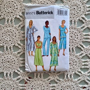 May include: A sewing pattern for a women's sleepwear set. The pattern includes five different styles: a long robe, a long-sleeved top and pants, a short-sleeved top and pants, a long dress, and a short dress. The pattern is from Butterick and the pattern number is B5571.