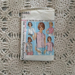 May include: A vintage Simplicity sewing pattern for a "How-to-Sew" pattern. The pattern is for a sleeveless blouse with a collar and a button-up front. The pattern number is 5285 and the size is 12 with a bust of 32 inches.