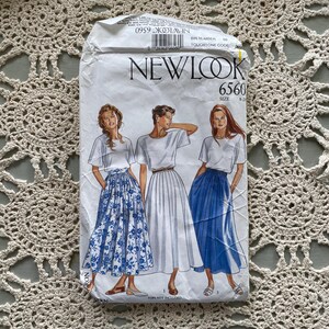 May include: A vintage New Look 6560 sewing pattern featuring illustrations of women in skirts and tops. The pattern packet shows three different skirt styles, including a blue floral print and a solid blue skirt. The text "TOPS NOT INCLUDED" is visible.