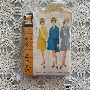 May include: Vintage McCall's sewing pattern for a dress and coat. The pattern is for misses', teen, and pre-teen sizes 12-14. The pattern number is 8676. The pattern is printed on a white background with black text.