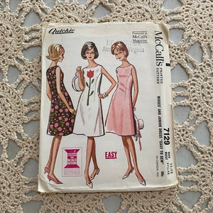 May include: Vintage McCall's sewing pattern for a dress, size 11-12, bust 31 1/2-32 inches. The pattern is titled "Quickie" and features three women wearing different versions of the dress. The dress is described as "Easy to Sew".