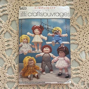 Peut inclure: Un patron de couture Simplicity pour confectionner des vêtements de poupée. Le patron est conçu pour des poupées de 40,5 cm et 45,5 cm. Le patron comprend des instructions pour réaliser une variété de tenues, notamment des robes, des pantalons et des chemises. Le patron comprend également un remerciement aux magasins de tissus.