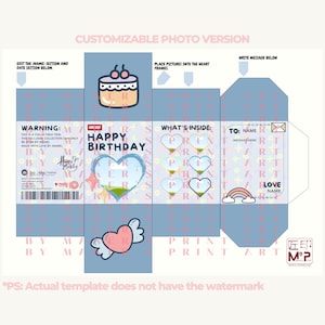 May include: A printable birthday card template with a blue background and pink accents. The card features a heart with a window to insert a photo, a cake, and the text "Happy Birthday".