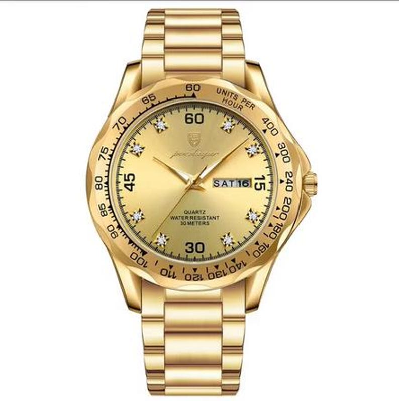 May include: A gold-tone analog wristwatch with a matching metal link band. The round face features a gold dial with crystal hour markers, luminous hands, a day-date window at the three o'clock position, and a tachymeter bezel with black markings.