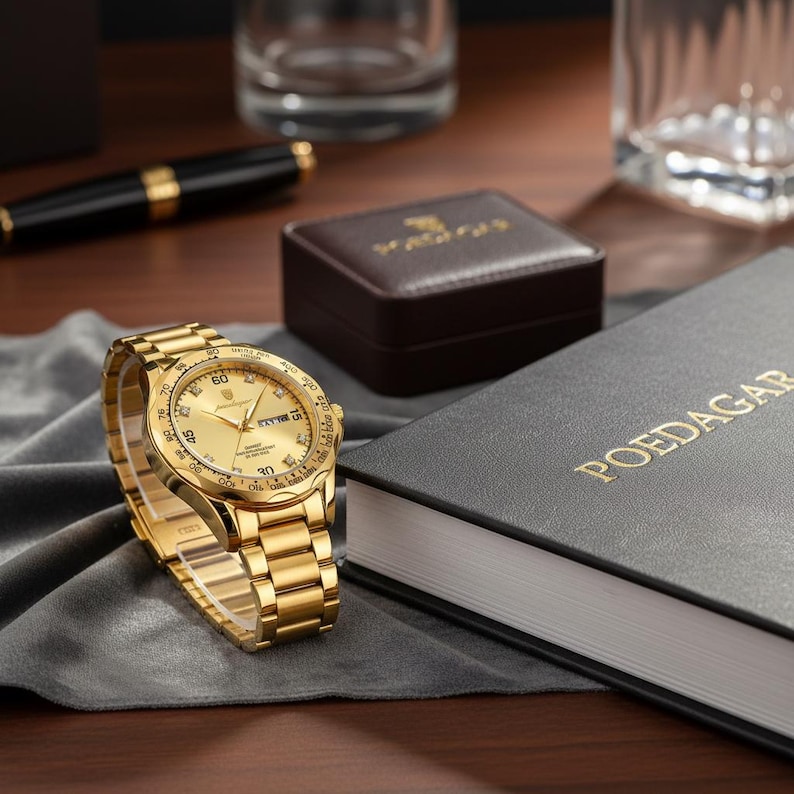 May include: A gold-tone analog wristwatch with a metallic link band and a round face featuring a gold dial, hour markers, and a date display. The watch is positioned near a black box with the gold text POEDAGAR and a matching small brown case.