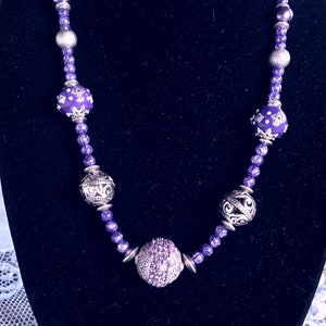 Purple and silver necklace made with fancy purple beads trimmed in silver and filigree gunmetal beads. 24 inches long, beaded necklace
