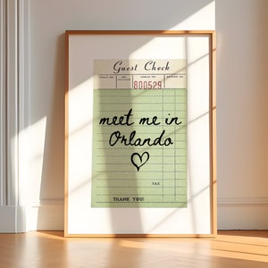 May include: A framed print of a vintage-style guest check with the text "meet me in Orlando" written in cursive with a heart symbol. The check number is 800529.
