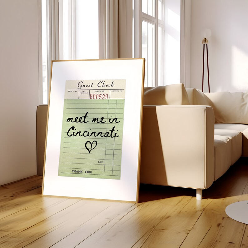 May include: A vintage-style guest check with the text "meet me in Cincinnati" written in black cursive with a heart drawn below the text. The check number is 800529.