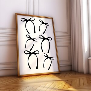 May include: A framed print with a white background and six black bow designs. The bows are arranged in a grid pattern.