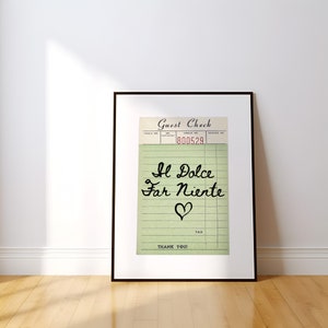 May include: A framed print of a vintage guest check with the text "Il Dolce Far Niente" written in cursive with a heart drawn below the text. The check number is 800529.