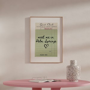 Puede incluir: Una impresi&oacute;n enmarcada de un cheque de hu&eacute;sped vintage con el mensaje escrito a mano "meet me in Palm Springs" y un coraz&oacute;n dibujado debajo. El n&uacute;mero de cheque es 800529.