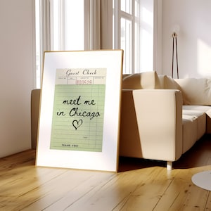 May include: A framed print of a vintage guest check with the text "meet me in Chicago" and a heart drawn on it.