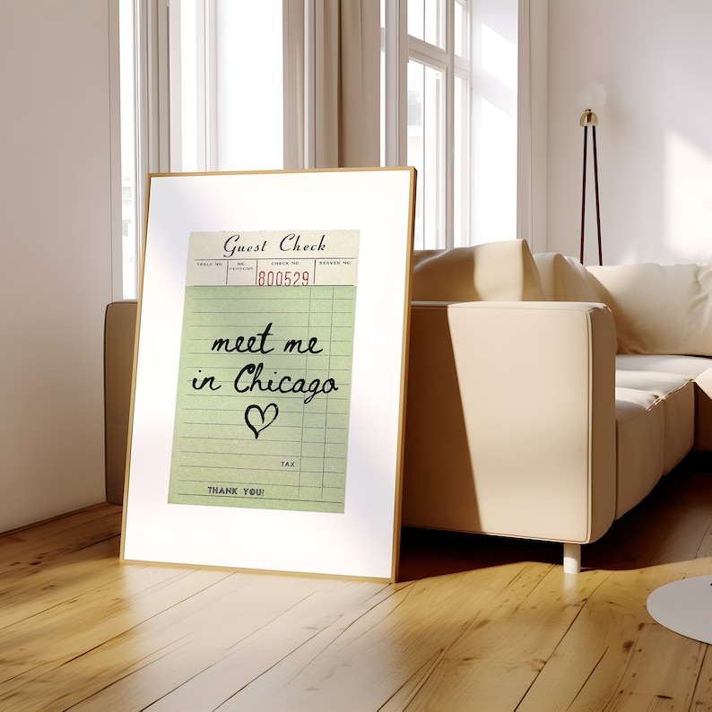 May include: A framed print of a vintage guest check with the text "meet me in Chicago" and a heart drawn on it.
