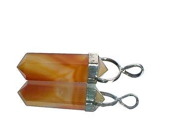 May include: A carnelian crystal pendant with a silver bail. The carnelian is a deep orange color with white streaks. The pendant is about 2 inches long.