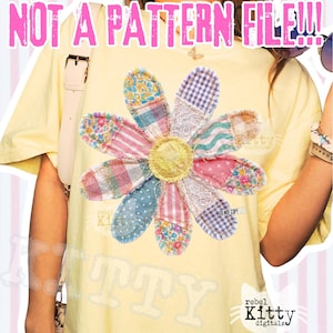 May include: A light yellow t-shirt featuring a large, colorful flower design. The flower petals are made of various patterned fabrics in shades of pink, blue, and floral prints. The text "NOT A PATTERN FILE!!!" is displayed at the top.