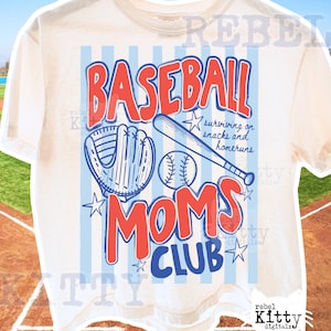 Puede incluir: Camiseta de color crema con un diseño temático de béisbol. El diseño incluye las palabras "BASEBALL MOMS CLUB" en rojo y azul, junto con un guante de béisbol, un bate y una pelota. La camiseta también tiene el texto "surviving on snacks and homeruns".