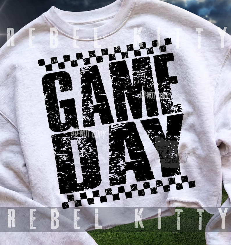 Pu&ograve; includere: Una felpa bianca a girocollo con una stampa grafica nera dall'aspetto usurato che riporta la scritta GAME DAY in grassetto maiuscolo. Il testo &egrave; incorniciato da due righe orizzontali di motivi a scacchi bianchi e neri sopra e sotto il design.