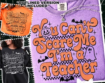 May include: A purple Comfort Colors sweatshirt with the text "You Can't Scare Me I'm a Teacher" in orange, black, and white. The design includes a jack-o'-lantern, bats, and a ghost, perfect for Halloween or teacher appreciation.