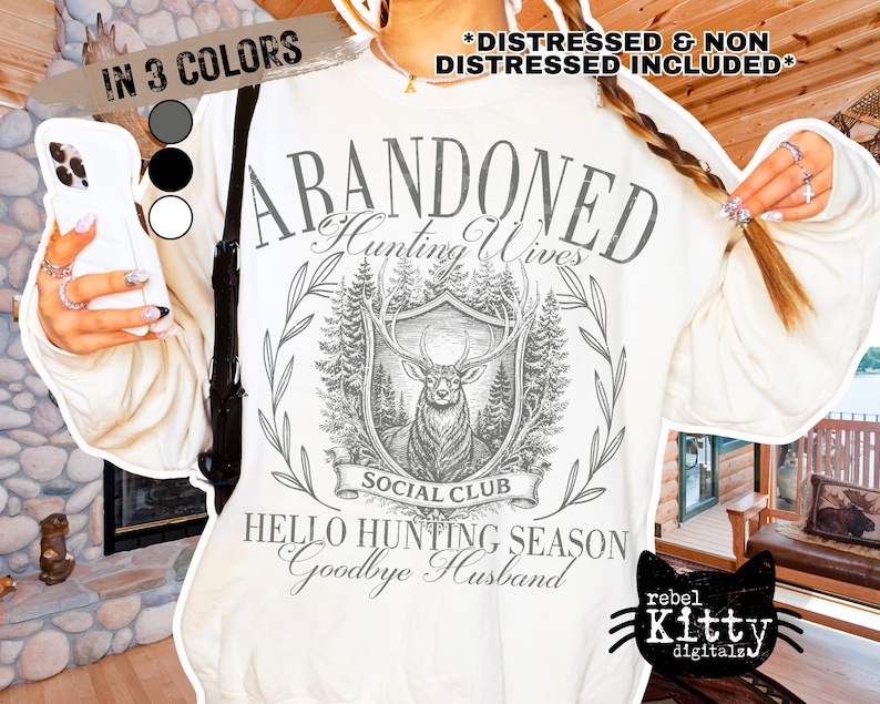May include: Cream-colored sweatshirt with a graphic design featuring a deer, trees, and the words "ABANDONED Hunting Wives Social Club." The text "HELLO HUNTING SEASON Goodbye Husband" is also present. The image includes color options.