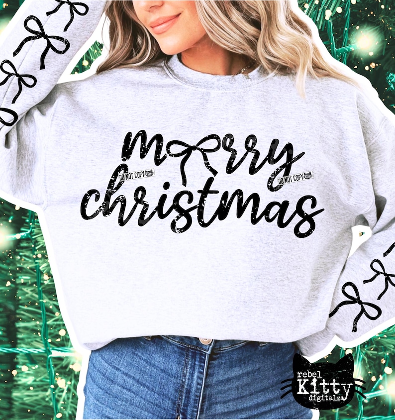 May include: A light gray sweatshirt with the words "merry christmas" in black script. The word "merry" has a bow design above it. Black bow designs are on the sleeves. The sweatshirt is paired with blue jeans.