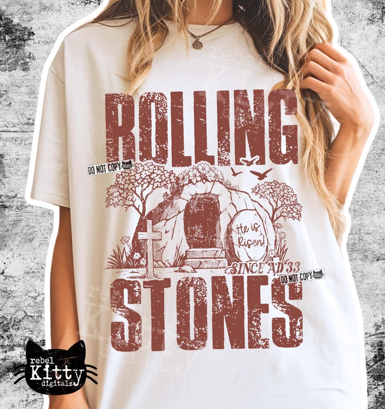 May include: Cream-colored t-shirt with a distressed brown graphic. The graphic features the words "ROLLING STONES" above and below an illustration of a tomb with a cross and the text "He is Risen! Since AD 33".