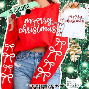 May include: A red Christmas sweatshirt with white text reading "merry christmas" and bow graphics. The sleeves feature vertical rows of white bows. A white t-shirt with the same design is also shown.
