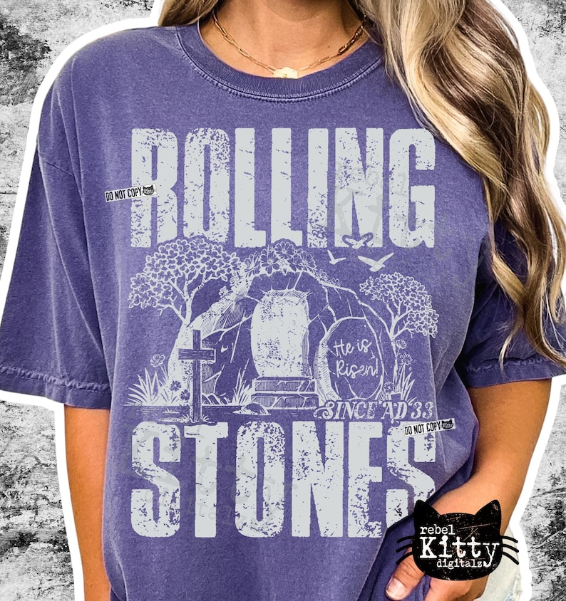 May include: Purple short-sleeved t-shirt with the words "ROLLING STONES" in large, distressed white letters. The design includes a cross, an open tomb, and the text "He is Risen! Since AD 33."