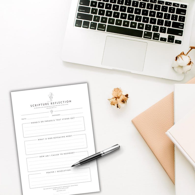 May include: A white paper sheet titled SCRIPTURE REFLECTION with sections for date, passage, words that stood out, what is God revealing here, how am I called to respond, and prayer or resolution, accompanied by a silver and black ballpoint pen.
