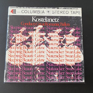 May include: A vintage 4-track stereo tape cassette with a black and white image of a ballerina on the front. The cassette is labeled "Columbia Masterworks" and features the text "Kostelanetz Conducts Great Romantic Ballets" and "Sleeping Beauty Gayne Nutcracker Swan Lake" repeated multiple times.